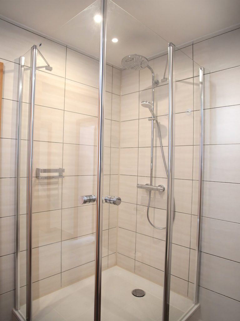 Modernes Bad der Ferienwohnung Markgraf mit Dusche, Waschbecken und heller Ausstattung