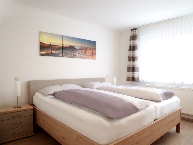 Schlafzimmer der Ferienwohnung Markgraf mit Doppelbett, Nachttischen und heller, ruhiger Atmosphaere