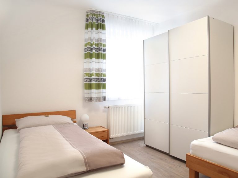 Schlafzimmer der Ferienwohnung Markgraf mit Einzelbetten, Kleiderschrank und Tageslicht
